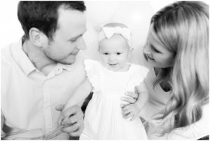 Parents looking at one year old baby girl by Raindancer studios Indianapolis Children Photographer Jill Howell