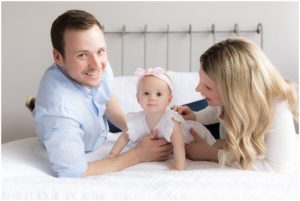 Parents and One year old daughter playing on a bed by Raindancer Studios Indianapolis Children Photographer Jill Howelll