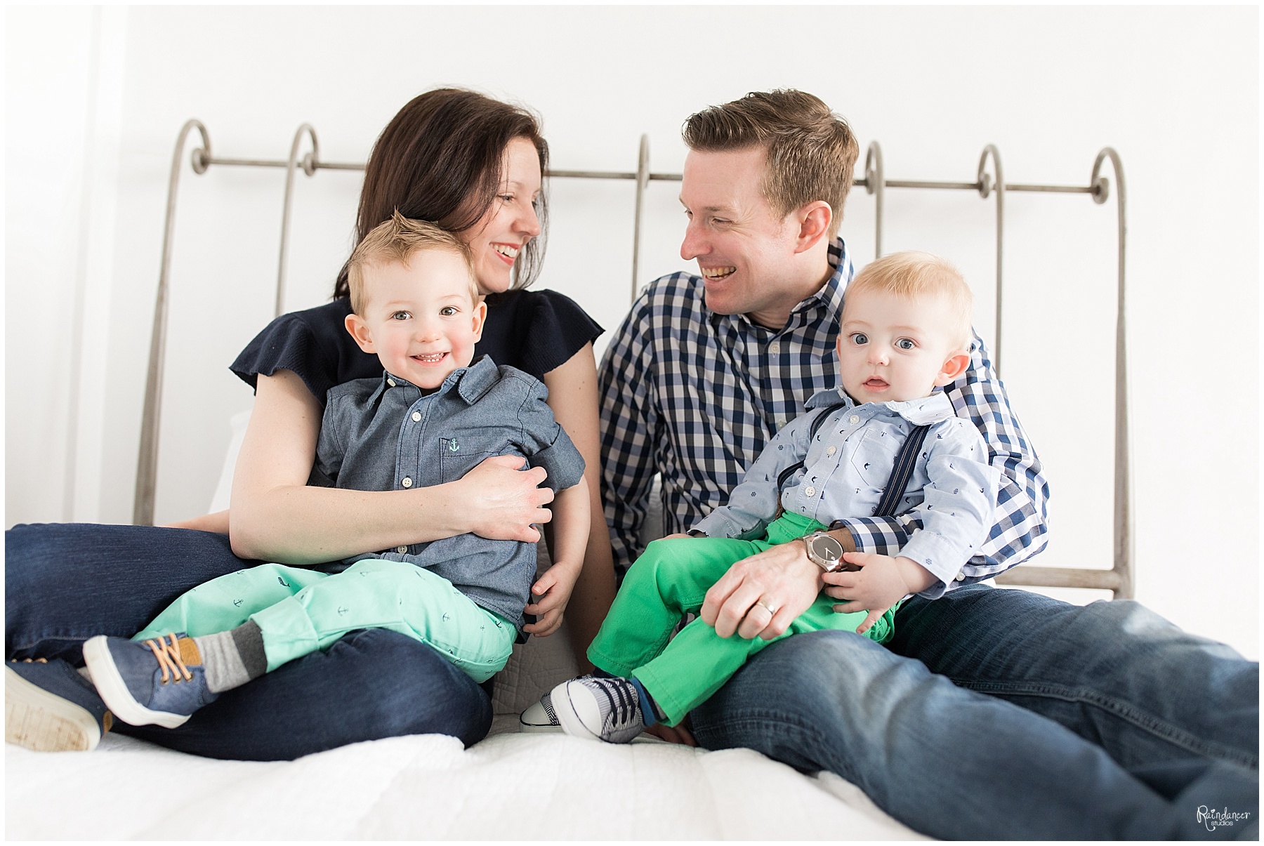 Parents and two sons sitting on bed together by Raindancer Studios Indianapolis Family Photographer Jill Howell