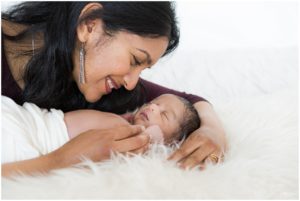Mother smiling at newborn baby boy sleeping by Raindancer Studios Indianapolis Newborn Photographer Jill Howell