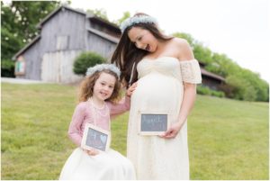 Mother and her little girl excited about baby sister coming in August