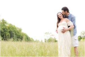 Husband kissing expecting wife in the fields, Indianapolis Maternity Photography