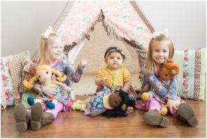 Three sisters sitting with baby dolls by a Matilda Jane Teepee. Indianapolis Children Photographer