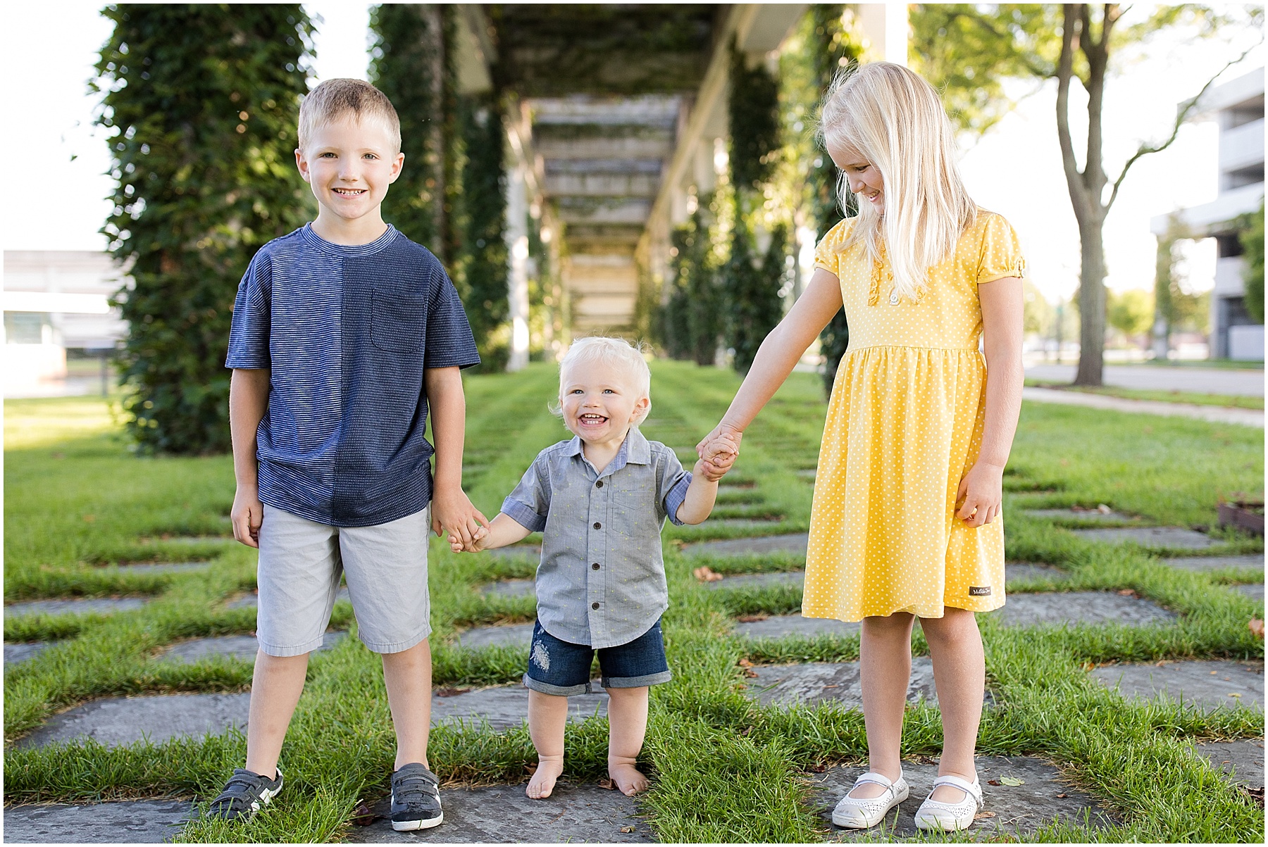 Brother and sister holding their one year old brothers hand, Columbus Family Photographer, Raindancer Studios