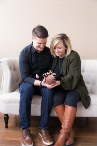 Mom and dad cradling newborn girl on sofa. Indianapolis Baby Photography